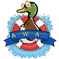 A cartoon mallard duck sits in the center of a red and white life preserver. The life preserver is surrounded by stylized splashes of blue water. A blue ribbon wraps across the bottom of the life preserver with "Accessible Waterways Association" written on it, using the "AWA" from the name as the main graphic element. The duck has large, surprised-looking eyes. The background is transparent.