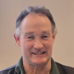 Mark Macaulay. A smiling man with a slightly receding hairline. His hair is dark grey.
