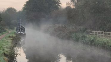 Hope in the darkness - a canal on a misty morning.