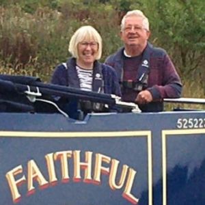 John and Gill Speight are pictured on the stern of their narrowboat "Faithful".